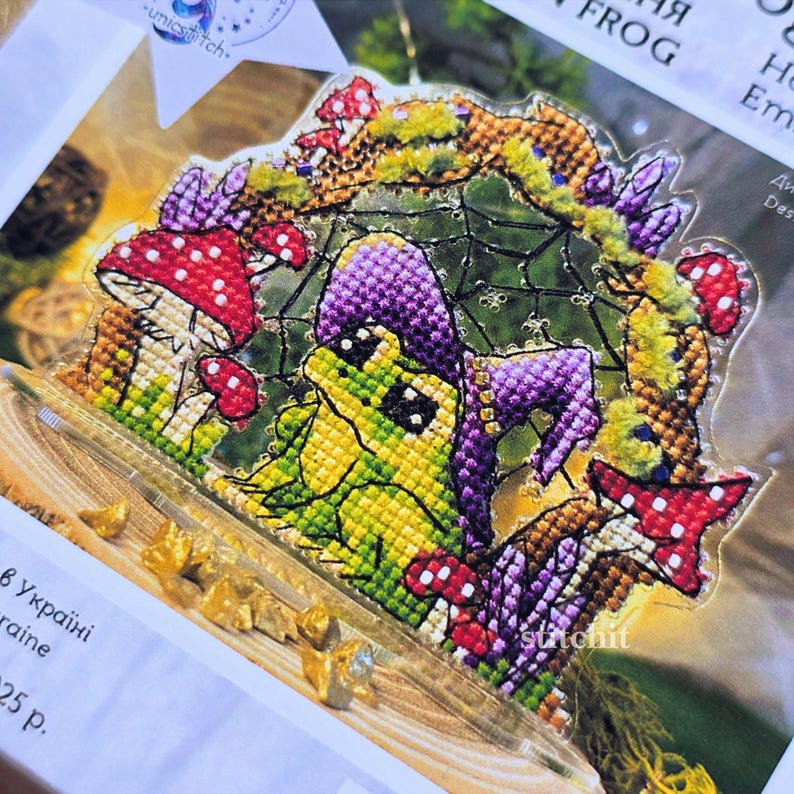 Halloween Frog Cross Stitch Kit — finished stitched frog in hat with mushrooms and flowers on clear plastic stand
