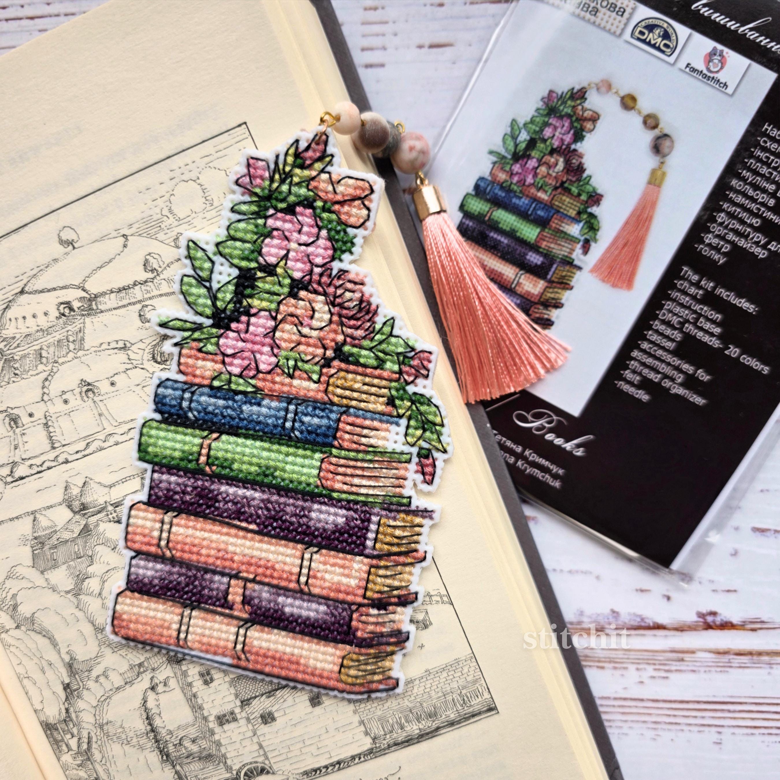 Cross Stitch Bookmark Kit on Plastic Canvas featuring a stack of colorful books and floral design with tassel.