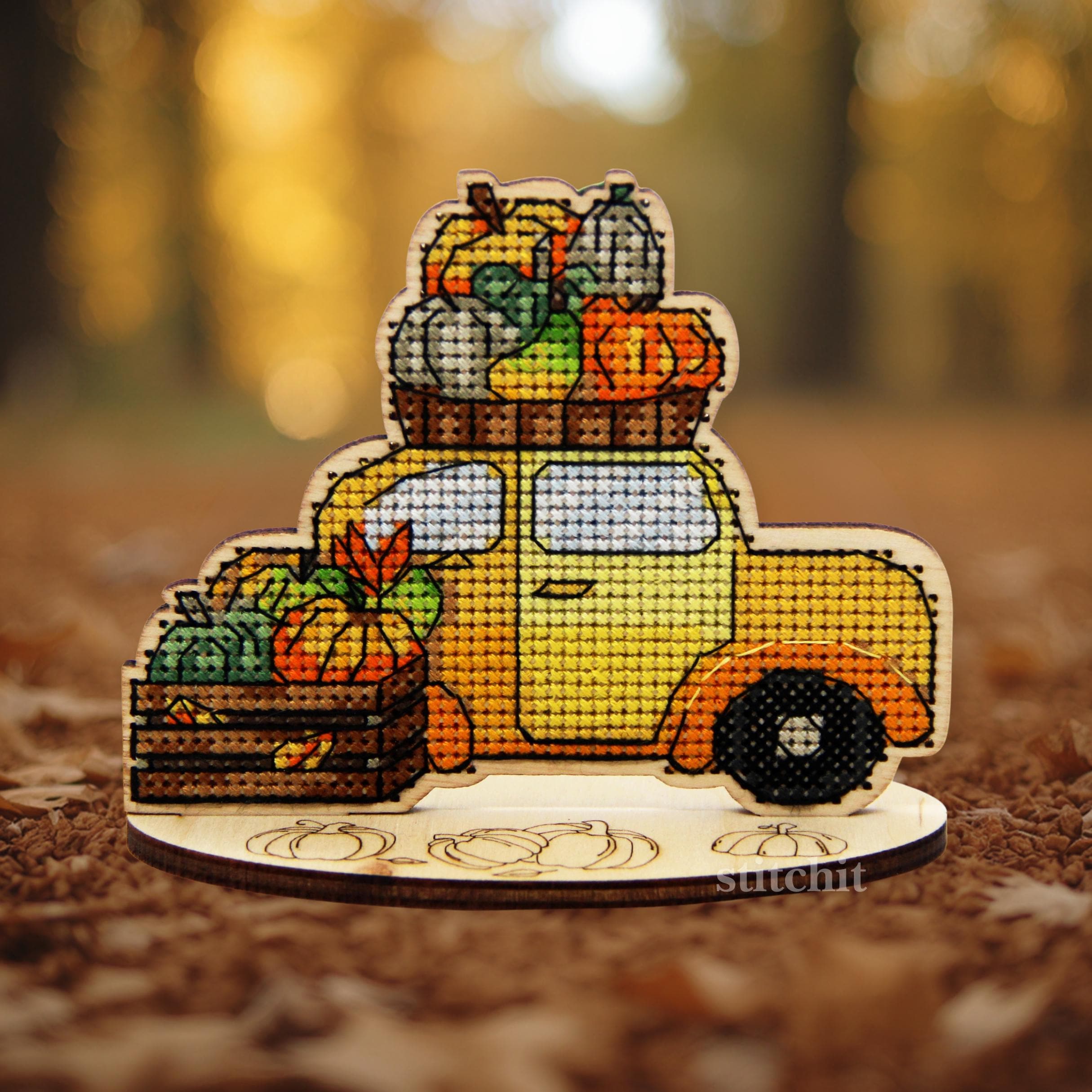 Autumn Car Cross Stitch Kit on Wood featuring a yellow truck filled with pumpkins and vegetables on a wooden base.